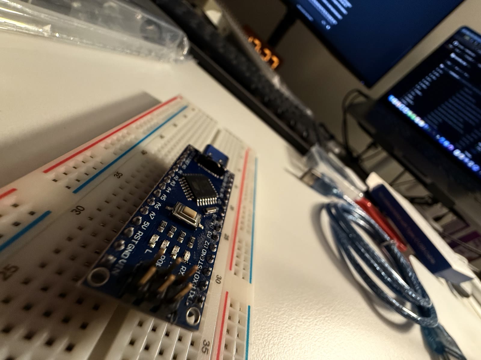 Arduino Nano seated across the center trench of a breadboard